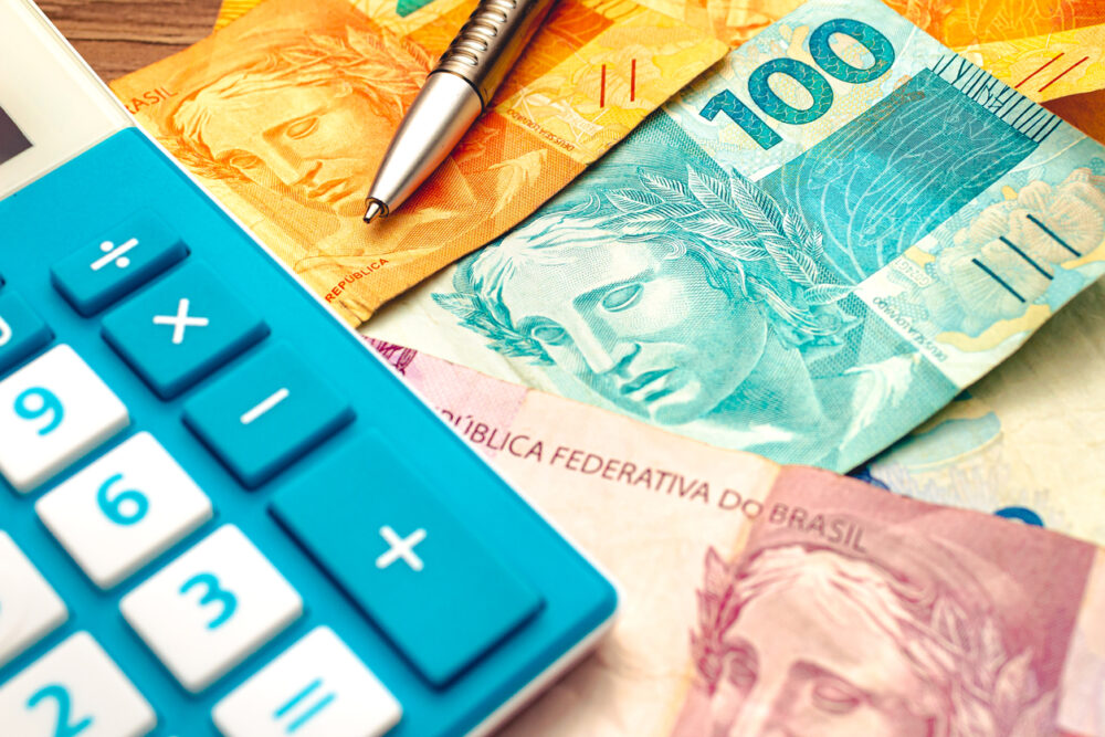 Real - money from Brazil. Brazilian Real banknotes on a wooden table with a calculator and pen in the composition. economics and financial planning